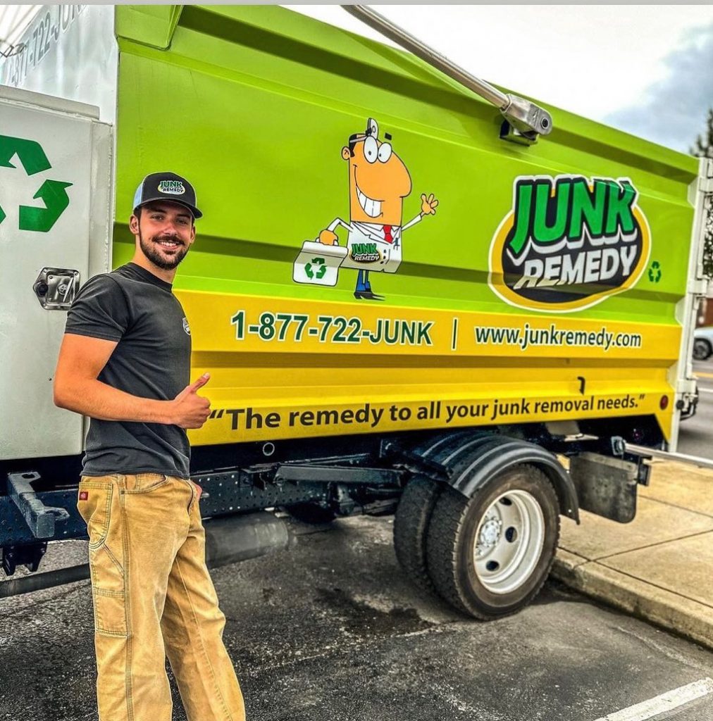 Junk Remedy Employee Giving a Thumbs Up Next to a Bright Green Junk Removal Truck